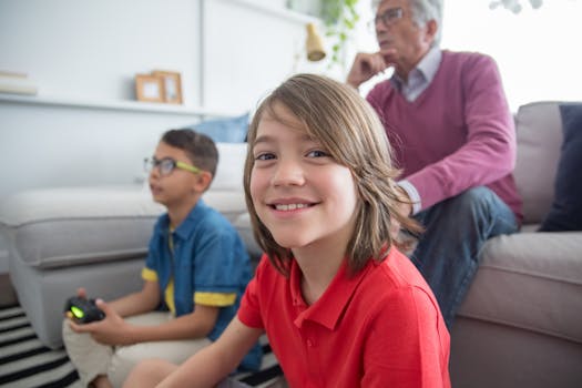 Happy children playing video games with their grandfather at home, enjoying family time and technology.